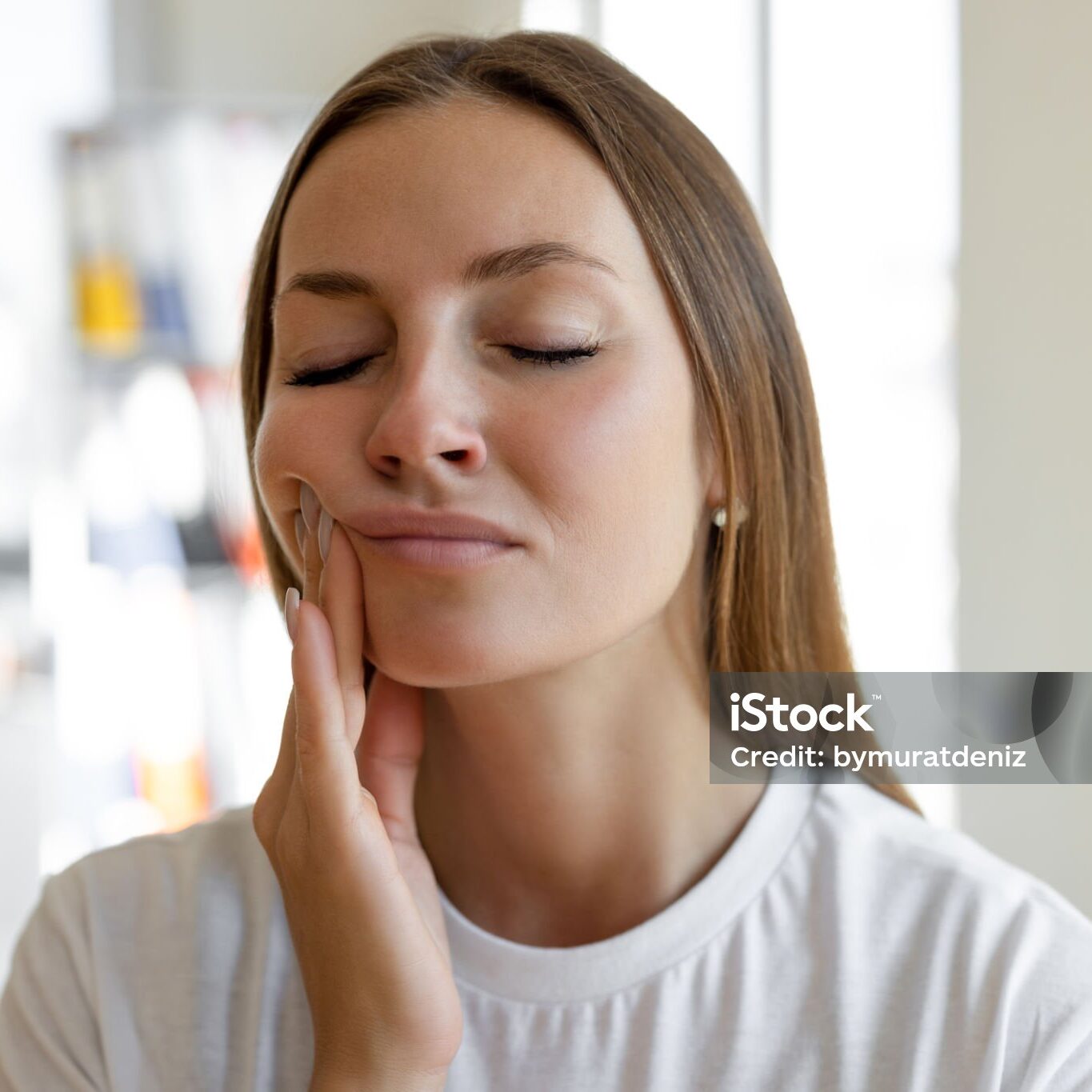 Woman experiencing toothache and holding her cheek