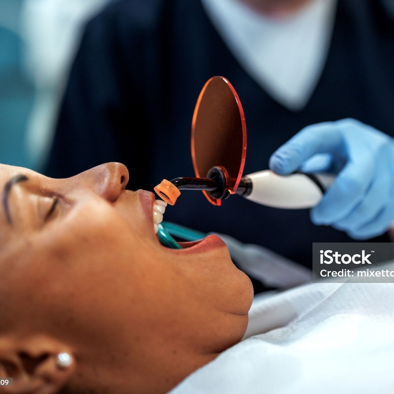 Professional female dentist carefully fitting a cheek retractor in a patient?s mouth, preparing for dental examination or treatment, showing precision, care, and a clinical dental environment.